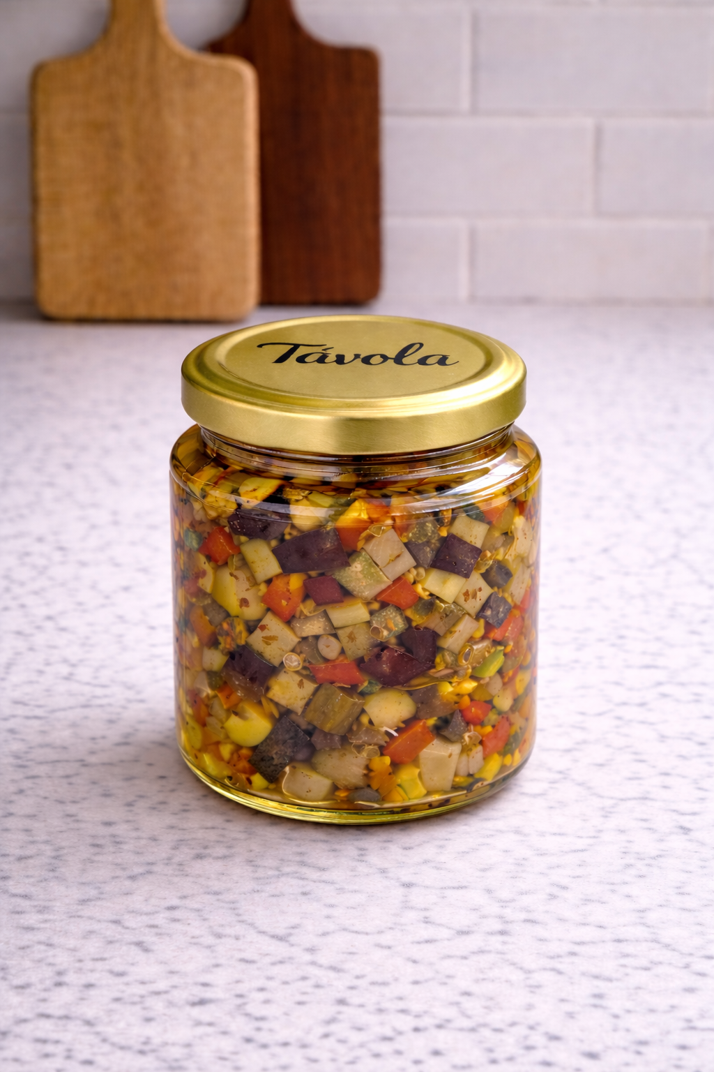 Pote de caponata de abobrinha com berinjela da Tavola sobre uma bancada clara.