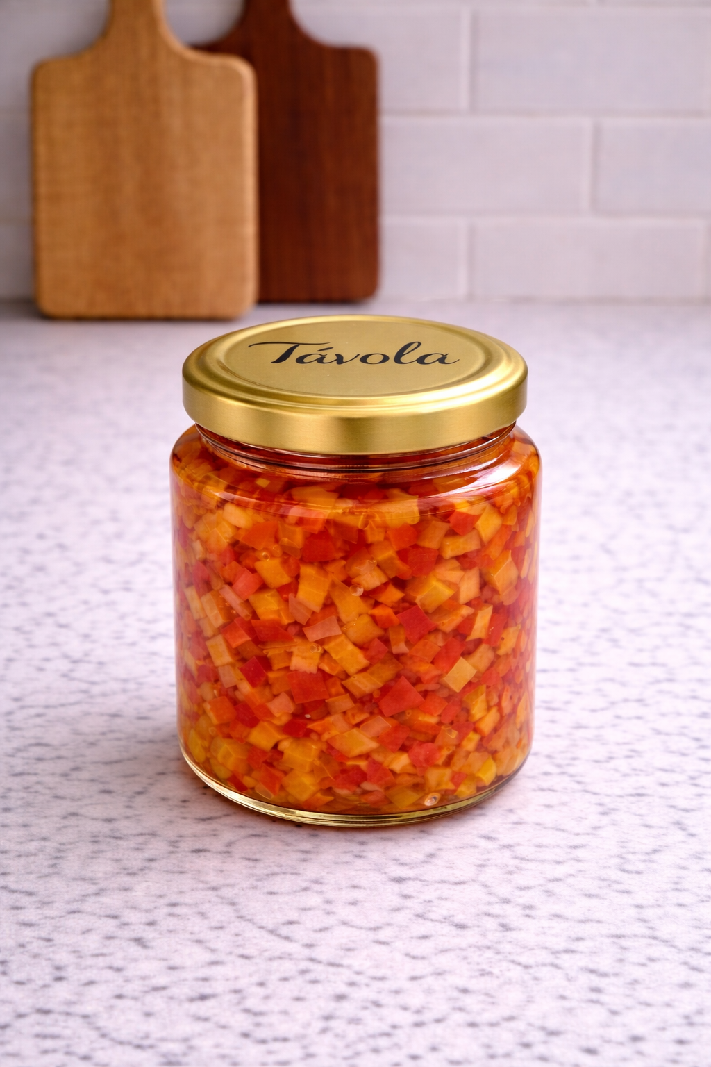 Pote de caponata de pimentões da Tavola sobre uma bancada clara.